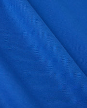 Close-up of blue fabric from the Psycho Bunny MENS CLASSIC PIQUE POLO SHIRT - B6K001CRPC, featuring a classic piqué polo texture. The material is lightweight and semi-transparent with uniformly distributed tiny holes throughout, creating a patterned appearance akin to fine Pima cotton.