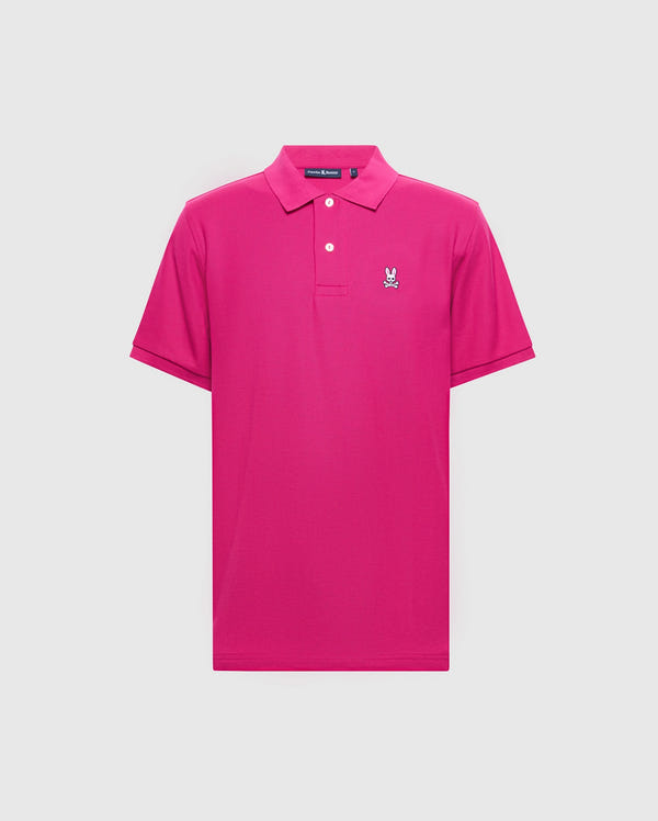 The Psycho Bunny Men's Classic Pique Polo Shirt (B6K001CRPC) is a bright pink Pima cotton polo with short sleeves, a collar, two white buttons, and an embroidered bunny with crossed bones on the left chest against a light gray background.