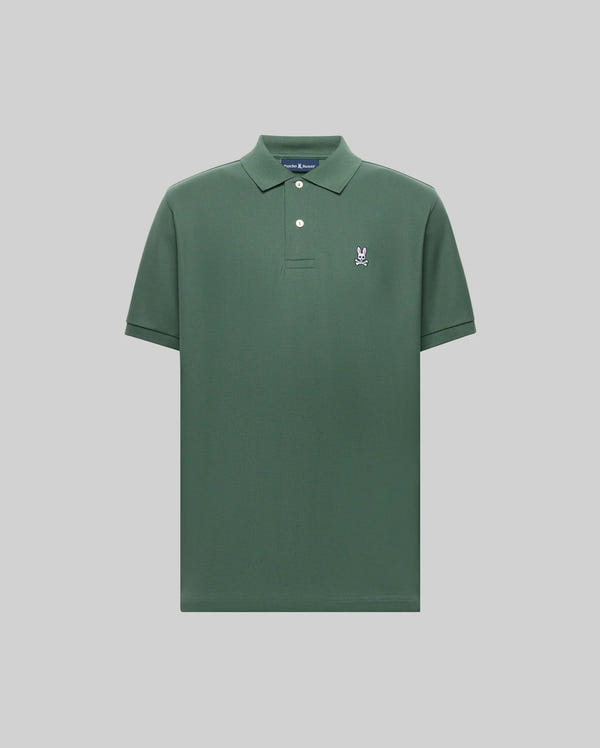 The Psycho Bunny MENS CLASSIC PIQUE POLO SHIRT - B6K001F200 is a dark green men's polo with short sleeves, a collar, two white buttons, and an embroidered white and blue Bunny logo on the left chest, set against a light gray background.