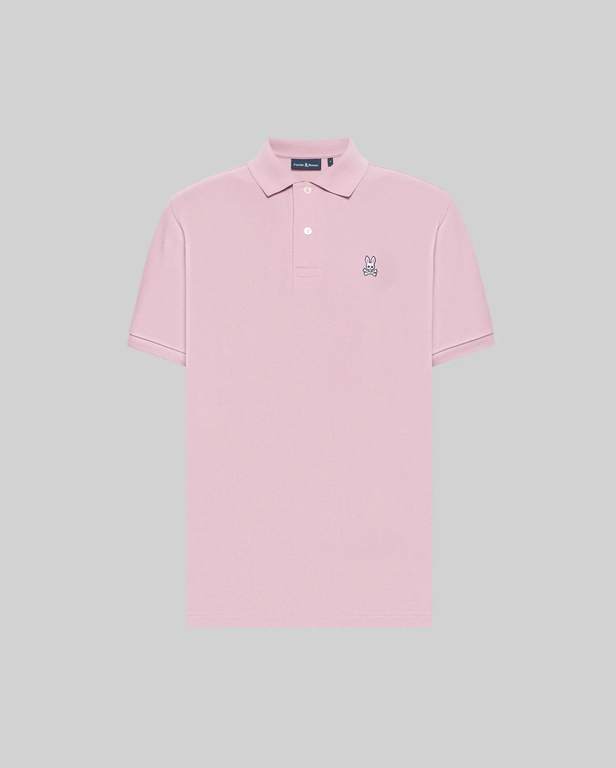 The Psycho Bunny MENS CLASSIC PIQUE POLO SHIRT (B6K001F200) is a light pink men’s polo in soft Pima cotton with short sleeves, a two-button collar, and an embroidered Bunny logo on the chest, shown on a plain gray background.