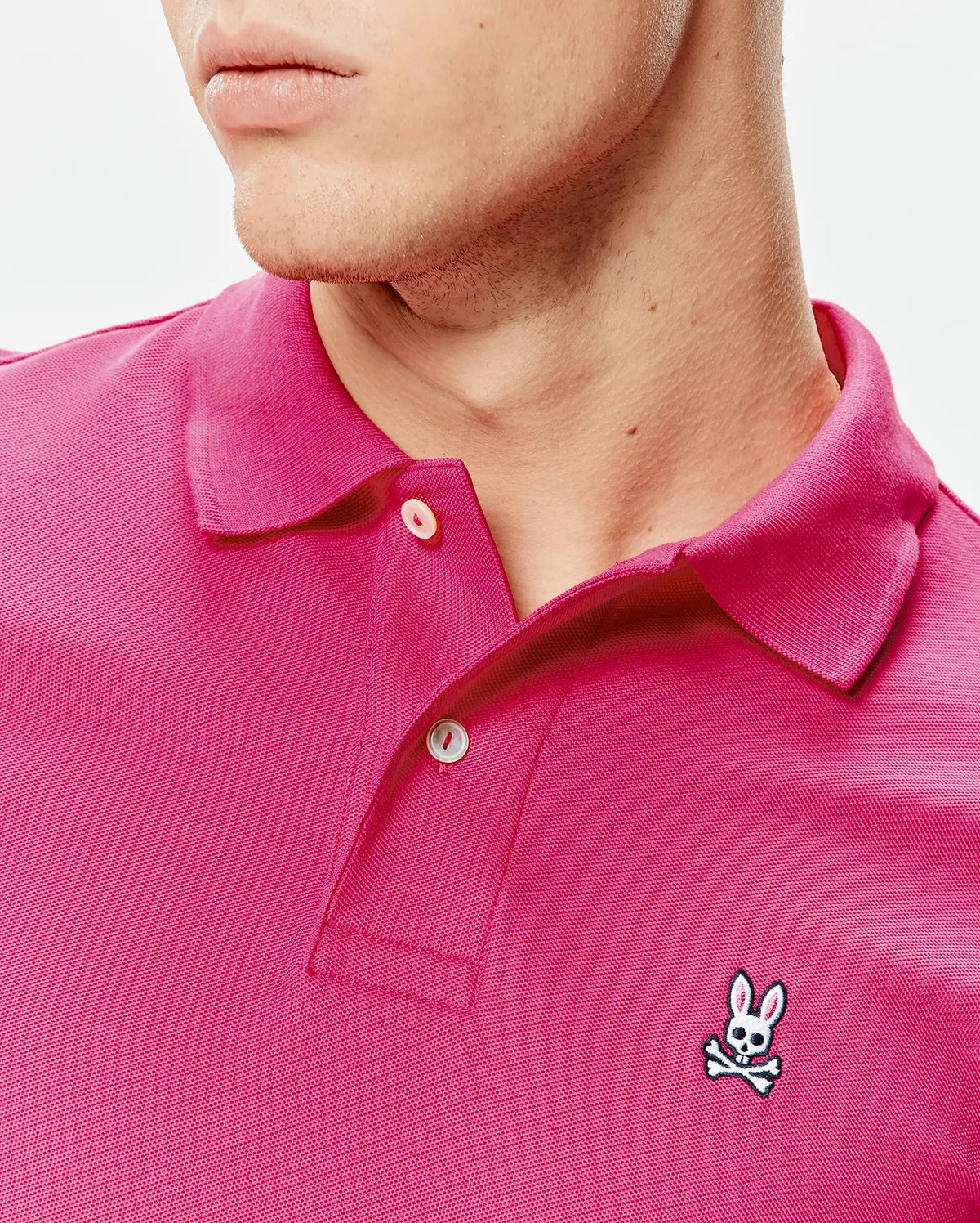 Mens Classic Pique Polo in vibrant fuchsia, featuring a classic fit, pique knit texture, two-button placket, and a small embroidered Psycho Bunny skull logo on the left chest. (3)