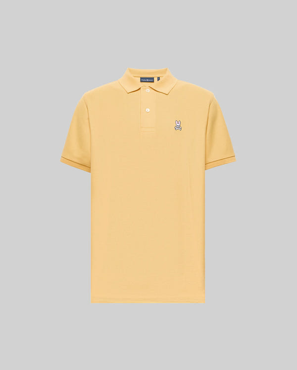 The Psycho Bunny MENS CLASSIC PIQUE POLO (B6K001F200) is a light yellow Pima cotton shirt with a collar, two buttons, and an embroidered Bunny logo on the left chest, shown on a plain gray background.
