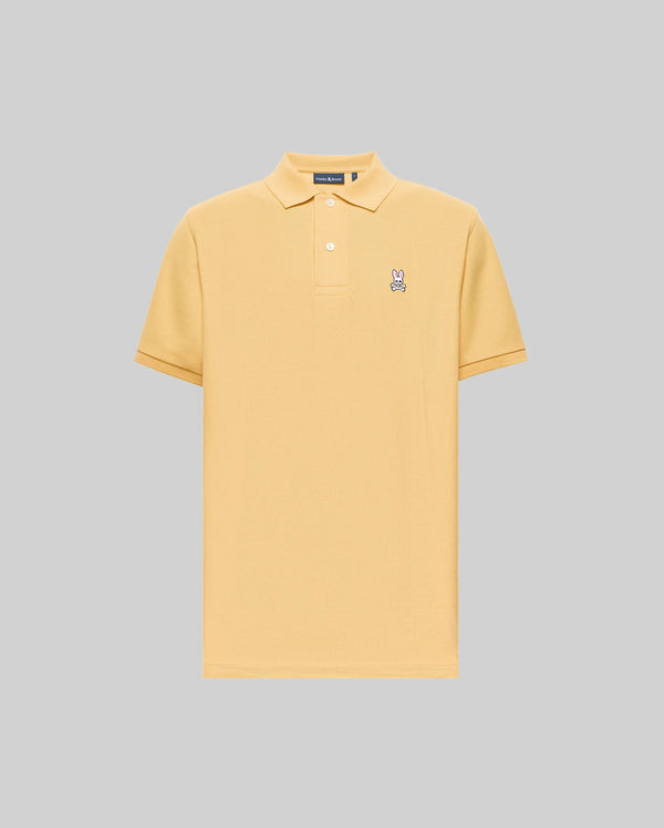 The Psycho Bunny MENS CLASSIC PIQUE POLO (B6K001F200) is a light yellow Pima cotton shirt with a collar, two buttons, and an embroidered Bunny logo on the left chest, shown on a plain gray background.