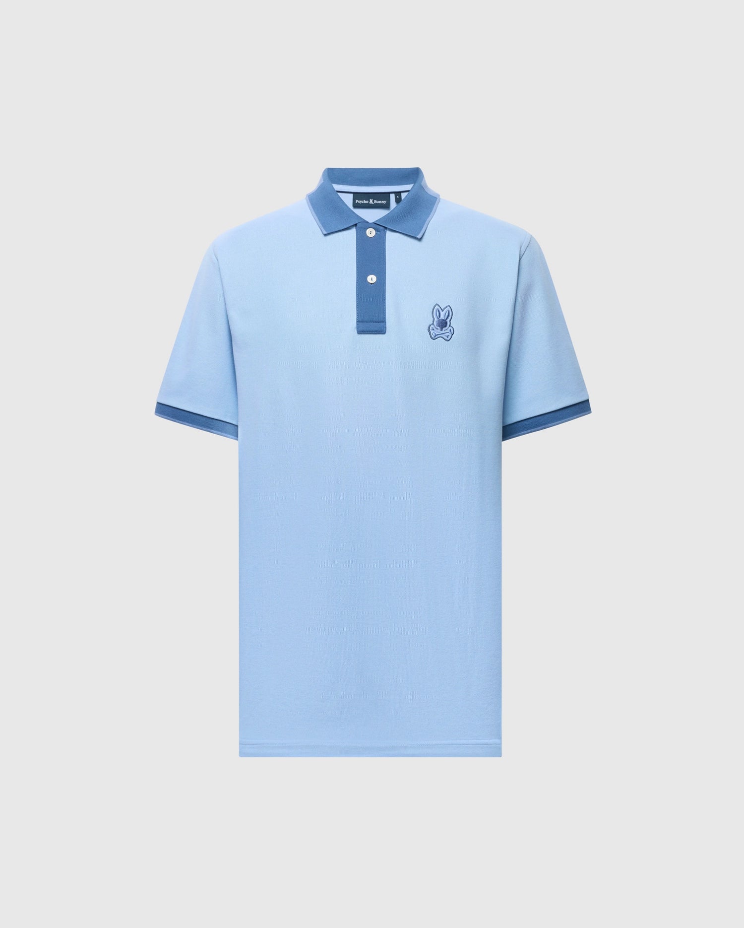 The Psycho Bunny Men's New Castle Pique Polo (B6K487F200) is a light blue slim fit with a navy collar and sleeve edges. It includes an embroidered bunny patch on the left chest, crafted from soft Pima cotton, featuring a two-button placket on a plain white background.