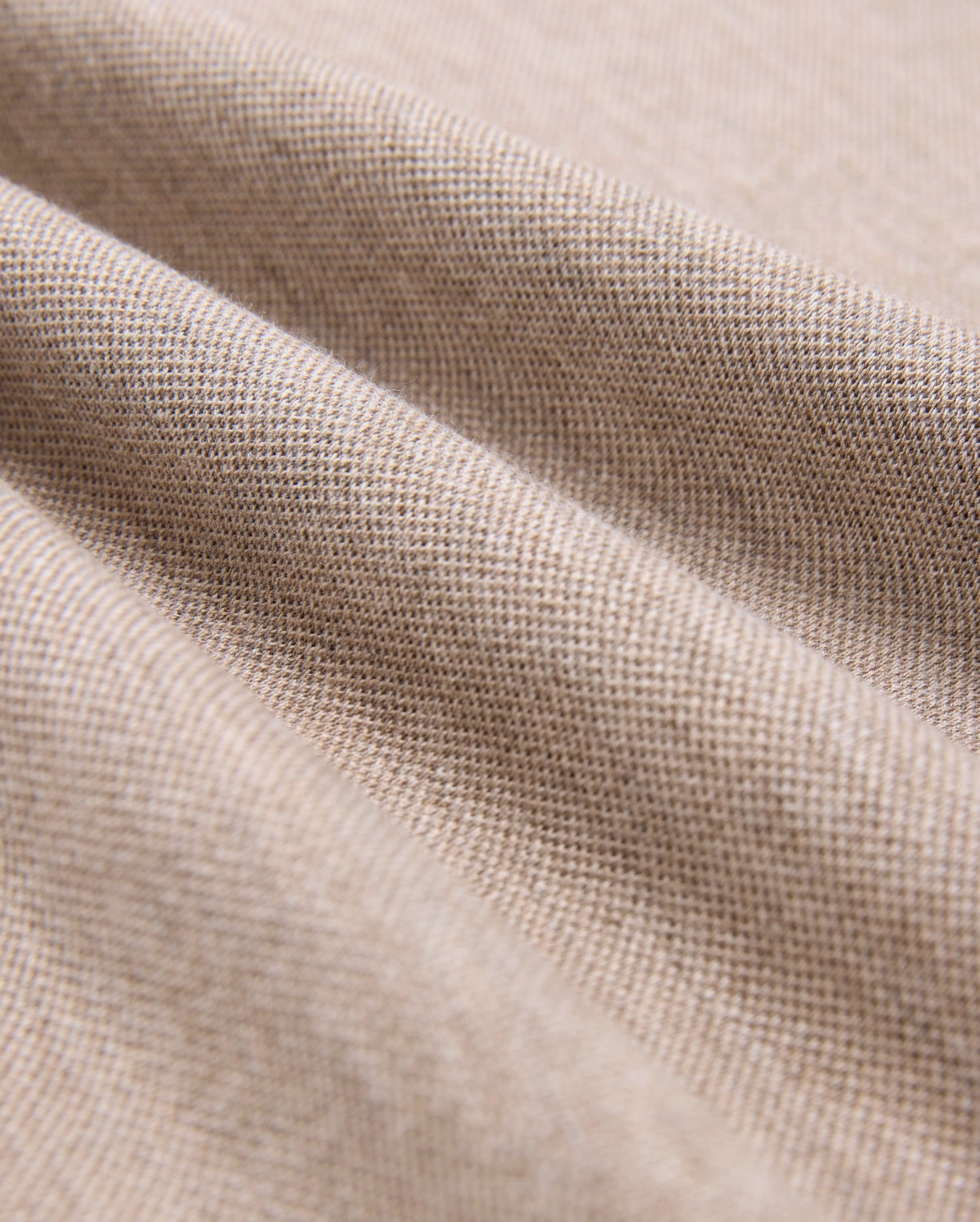 Close-up of Psycho Bunny's MENS JAMES PREMIUM PIQUE POLO SHIRT fabric, crafted from premium materials, showing a fine weave with soft folds. The smooth, uniform texture has gentle undulations and subtle shadows—ideal for a durable yet luxurious wear.