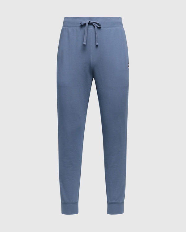 The MENS LEVY ESSENTIAL FLEECE SWEATPANT - B6P721D200 by Psycho Bunny are blue jogger pants with an elastic waistband and drawstring, featuring ribbed cuffs. Crafted from soft fleece, these comfortable sweatpants are perfect for casual wear.