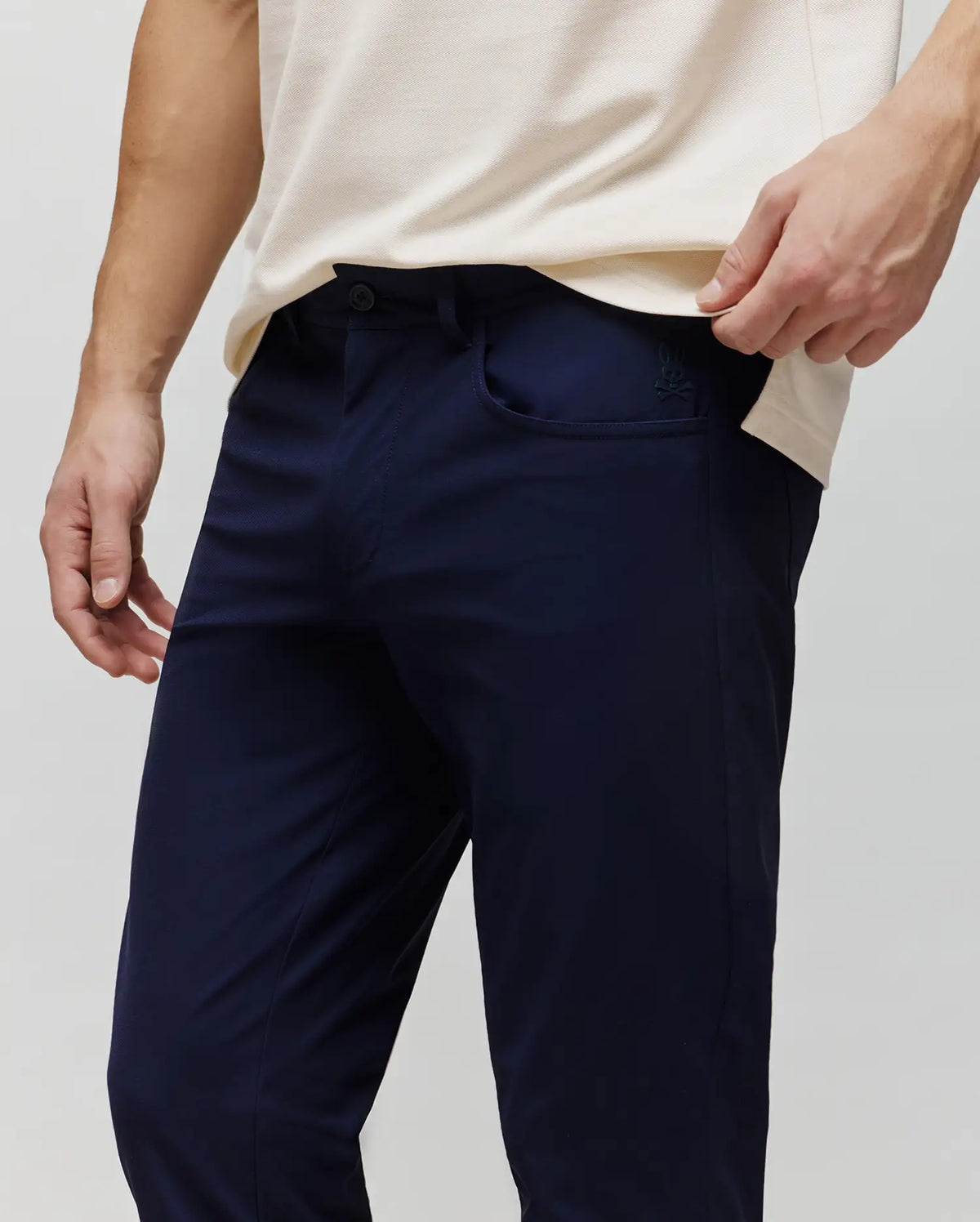 Navy Mens Maverick 10k Step Pant, a slim fit style crafted from smooth performance fabric, featuring a small embroidered Psycho Bunny skull logo on the right front pocket.