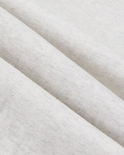 Close-up view of a light gray, cotton-blend fabric with a soft, heathered texture. The fabric is folded in parallel lines, showcasing its smooth and slightly speckled surface—ideal for crafting premium bottoms like the Psycho Bunny MENS JAMES PREMIUM SWEATPANT - B6P791D200.