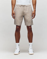 Wearing Psycho Bunny’s MENS WINDCREST LINEN BLEND DRAWSTRING SHORT (B6R474C200), a white tank top, crew socks, and white sneakers, a person stands against a plain light background. Image is cropped from shoulders to feet.