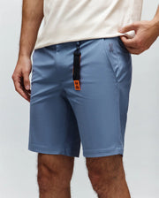 Mens Maverick 10k Step Short in slate blue, crafted from smooth performance fabric with a classic fit, featuring a small embroidered Psycho Bunny skull logo on the right hip and a black and orange branded keychain.