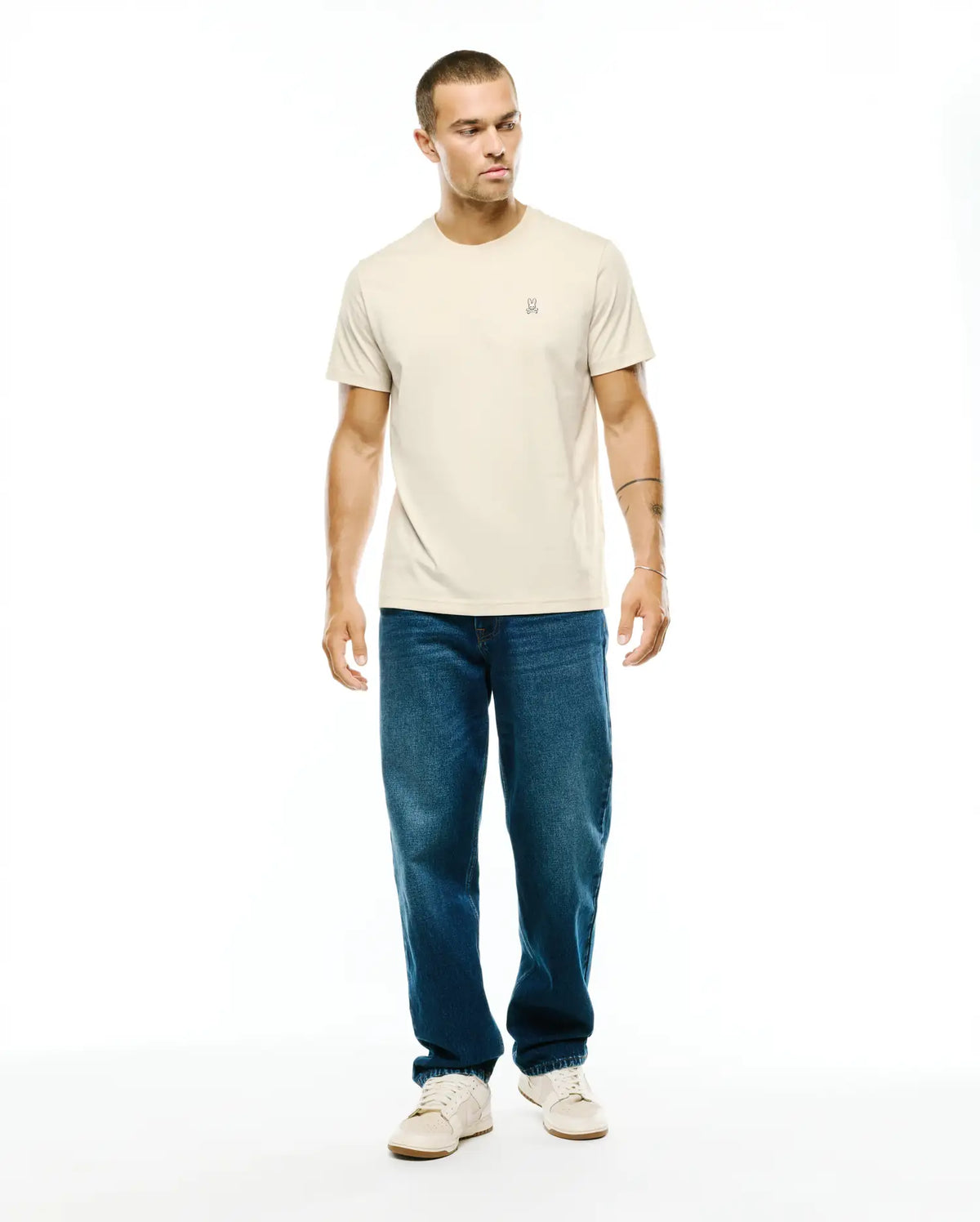 Mens Classic Crew Neck Tee in a light beige, smooth jersey knit with a classic fit, featuring a small, embroidered Psycho Bunny skull logo on the left chest. (4)