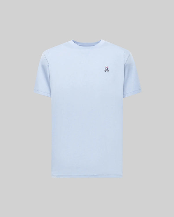 The Psycho Bunny MENS CLASSIC CREW NECK TEE - B6U014F200 is a light blue Pima cotton men's tee with a small embroidered peace sign on the left chest, shown on a gray background.