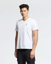 A person in Psycho Bunny's MENS CLASSIC V NECK TEE (B6U100ARPC), a white 100% Pima cotton tee with a small embroidered logo on the chest, stands against a plain backdrop in black pants.