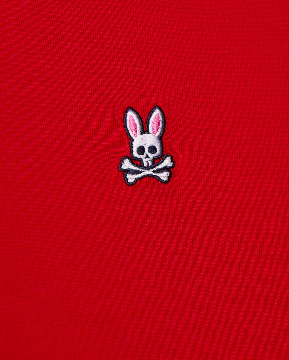 The MENS CLASSIC V NECK TEE - B6U100CRPC from Psycho Bunny showcases a red fabric made of soft Pima cotton and features the brand's signature logo: a white skull and crossbones with playful pink bunny ears.