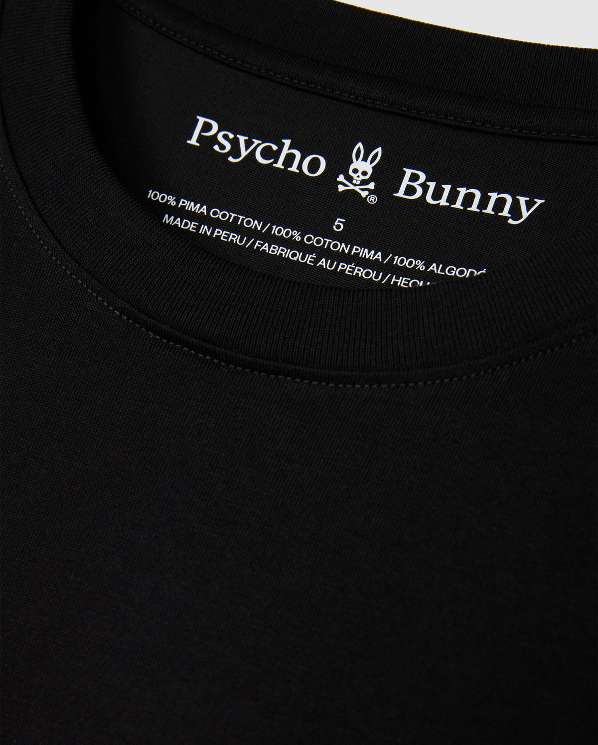 Close-up of the MENS HAWAII CITY TEE by Psycho Bunny, highlighting the black label inside the collar featuring its iconic logo and text indicating it's crafted from 100% Pima cotton, made in Peru.