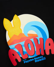 The MENS HAWAII CITY TEE - B6U169Y1PC by Psycho Bunny showcases a vibrant graphic design on a black background, highlighting a yellow sun with bunny ears, a blue wave, and striking red "Aloha" text. Made from premium Pima cotton, this T-shirt also features "from Psycho Bunny Hawaii" at the bottom, making it an ideal addition to your Hawaii tee collection.