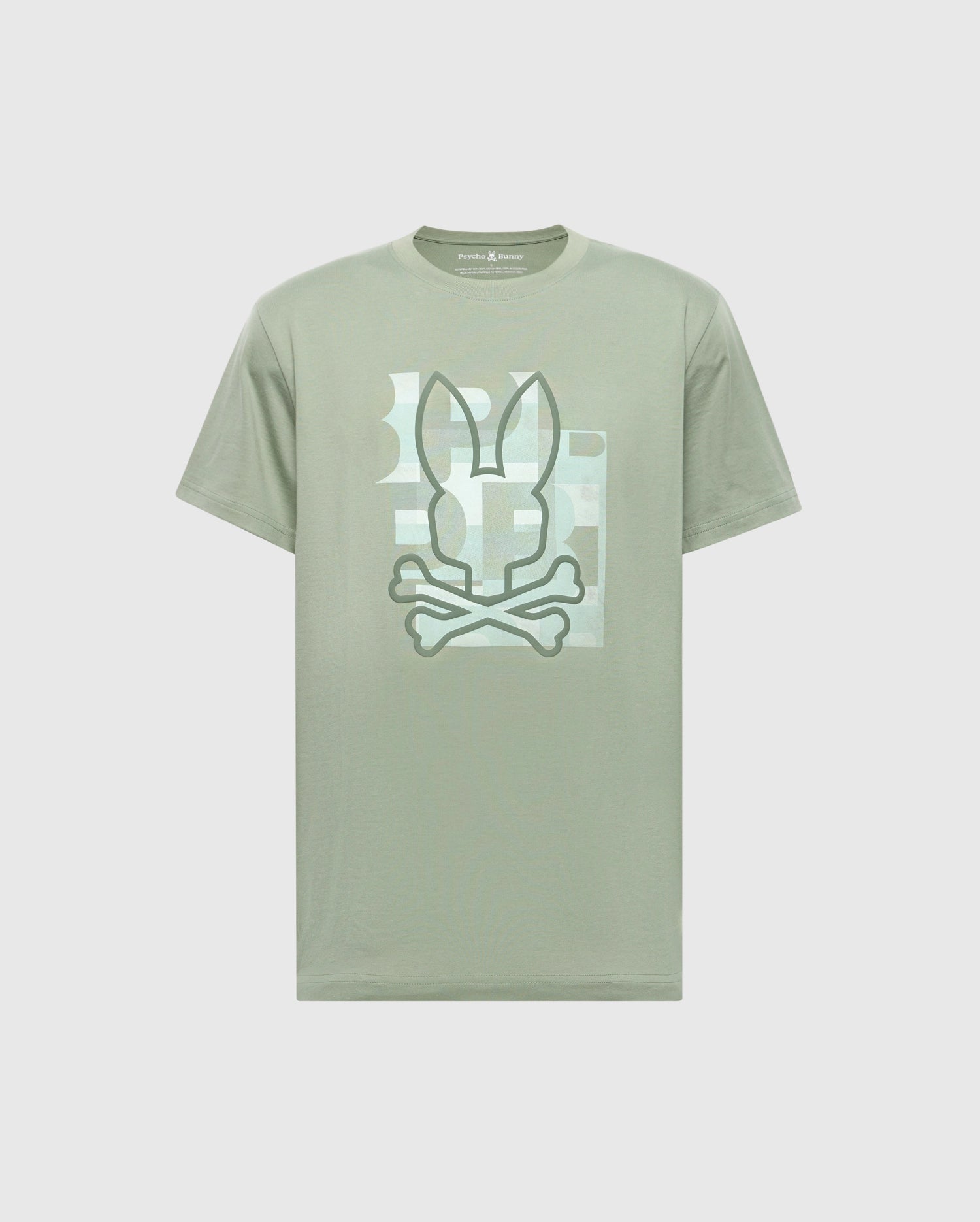 The Psycho Bunny MENS ZEALAND GRAPHIC TEE (B6U604F200) is a light green shirt with a stylized bunny ears and crossed bones graphic on the chest, framed by a subtle rectangular background pattern.
