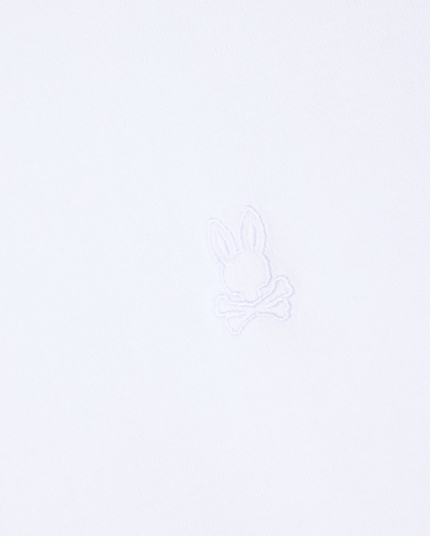 The MENS DUKE OVERSIZED TEE - B6U742D200 by Psycho Bunny is crafted from heavyweight Pima cotton and features a subtle, minimalist embroidered logo in the center, showcasing a bunny head above crossed bones. The matching white embroidery seamlessly blends with the fabric, providing a relaxed fit.