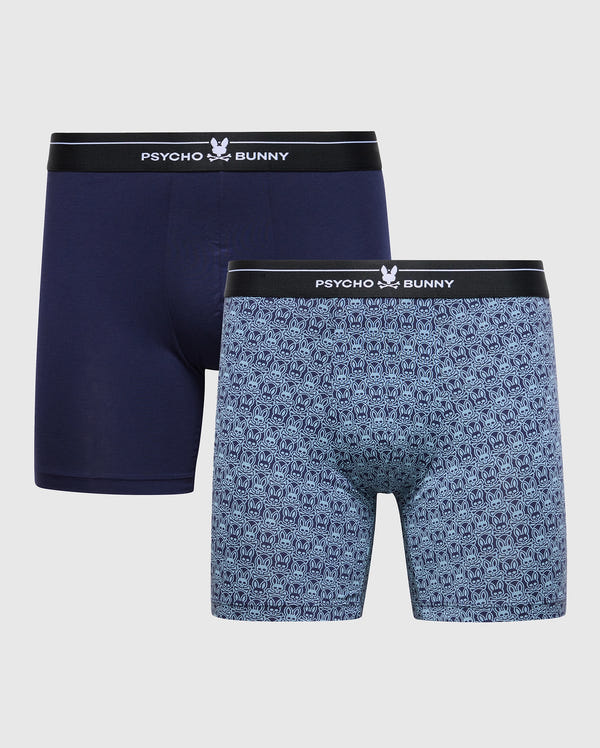 This Psycho Bunny MENS 2 PACK BOXER BRIEF (B6V481F200) features two pairs of soft-knit, breathable, stretch Pima cotton boxer briefs: one in solid navy and the other with a blue and black pattern. Both have black waistbands with "PSYCHO BUNNY" text and a bunny logo.