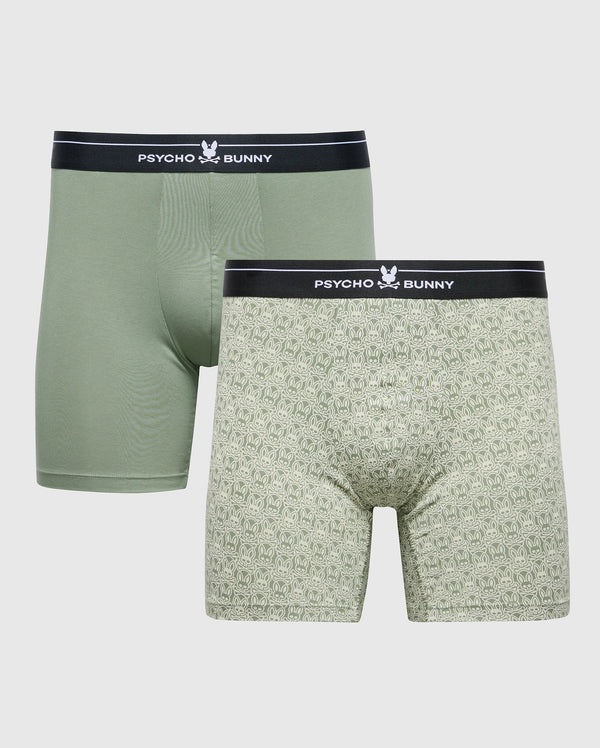 The MENS 2 PACK BOXER BRIEF - B6V481F200 by Psycho Bunny includes one solid olive green pair and a patterned pair in a lighter shade. Made from a Pima cotton-Modal blend, they ensure all-day comfort with black waistbands featuring the "Psycho Bunny" logo and a white bunny emblem.