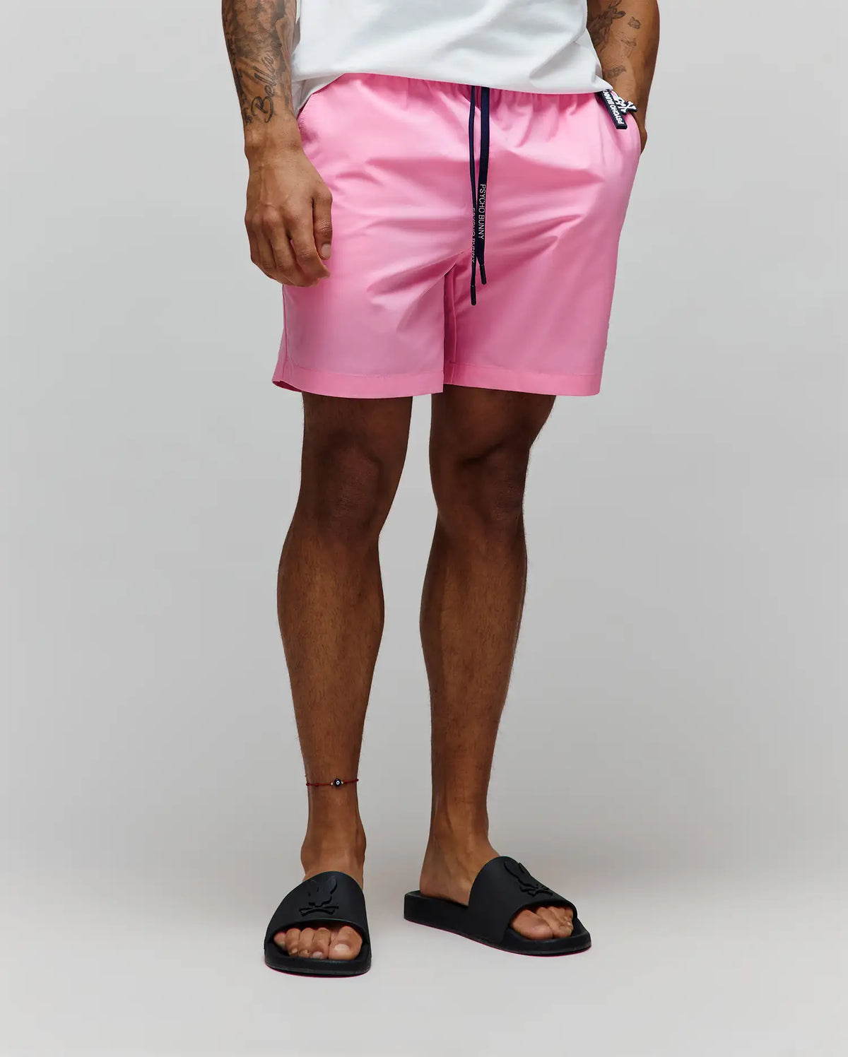 Mens Samos Hydrochromic Printed Swim Trunk in pink, featuring a relaxed fit, smooth quick-dry fabric, navy drawstring with white Psycho Bunny branding, and a small black bunny skull logo tag on the right hip. (3)