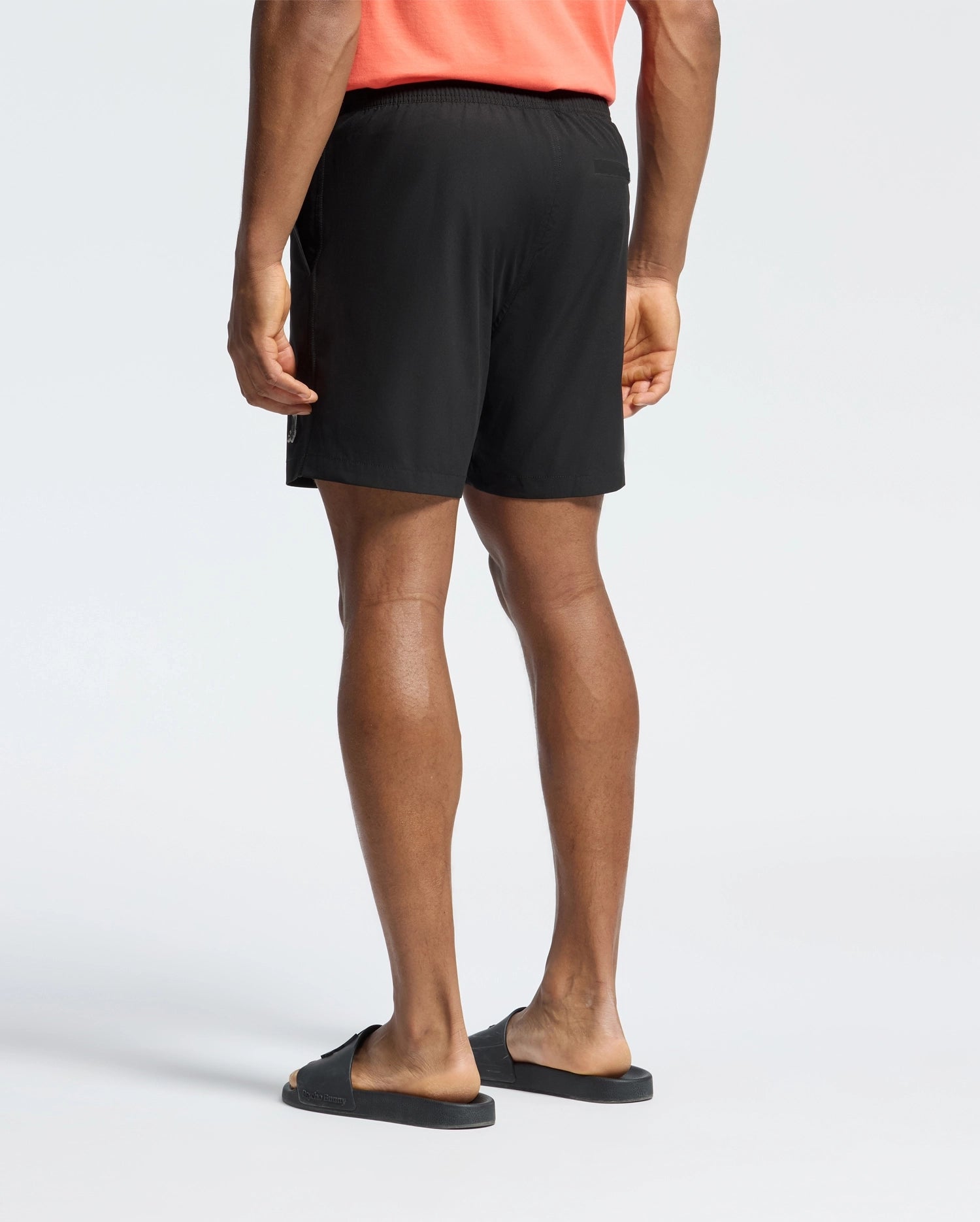 Mens Samos Hydrochromic Printed Swim Trunk in black, featuring a relaxed fit, smooth quick-dry fabric, elastic waistband, side pockets, and a small white Psycho Bunny skull logo on the left leg.