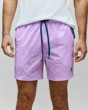 Mens Samos Hydrochromic Printed Swim Trunk, lavender with subtle repeating bunny skull pattern, dark teal drawstring, small embroidered Psycho Bunny logo on lower left leg.