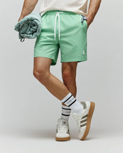 Mens Samos Hydrochromic Printed Swim Trunk in mint green, featuring a relaxed fit, smooth quick-dry fabric, white drawstrings with Psycho Bunny text, and a small embroidered bunny skull logo on the left leg.