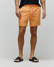 Mens Samos Hydrochromic Printed Swim Trunk, vibrant orange, relaxed fit, smooth quick-dry fabric. Features pink drawstring with Psycho Bunny text and a small embroidered pink bunny skull logo on the left leg.