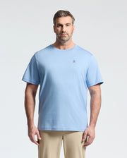 A bearded man with short hair wears a light blue Psycho Bunny BIG AND TALL CLASSIC CREW NECK TEE (B9U014Z1PC) made of 100% Pima cotton, featuring a small embroidered logo on the left chest. He faces forward against a plain light background, paired with beige pants for a timeless look.