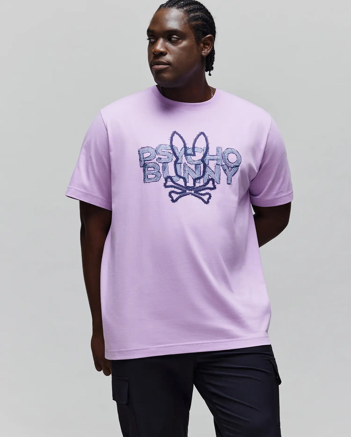 Mens Big And Tall Herman Graphic Tee, a lavender jersey relaxed fit t-shirt with a large central distressed dark blue Psycho Bunny skull logo and text graphic.