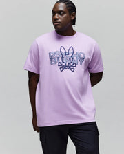 Mens Big And Tall Herman Graphic Tee, a lavender jersey relaxed fit t-shirt with a large central distressed dark blue Psycho Bunny skull logo and text graphic.