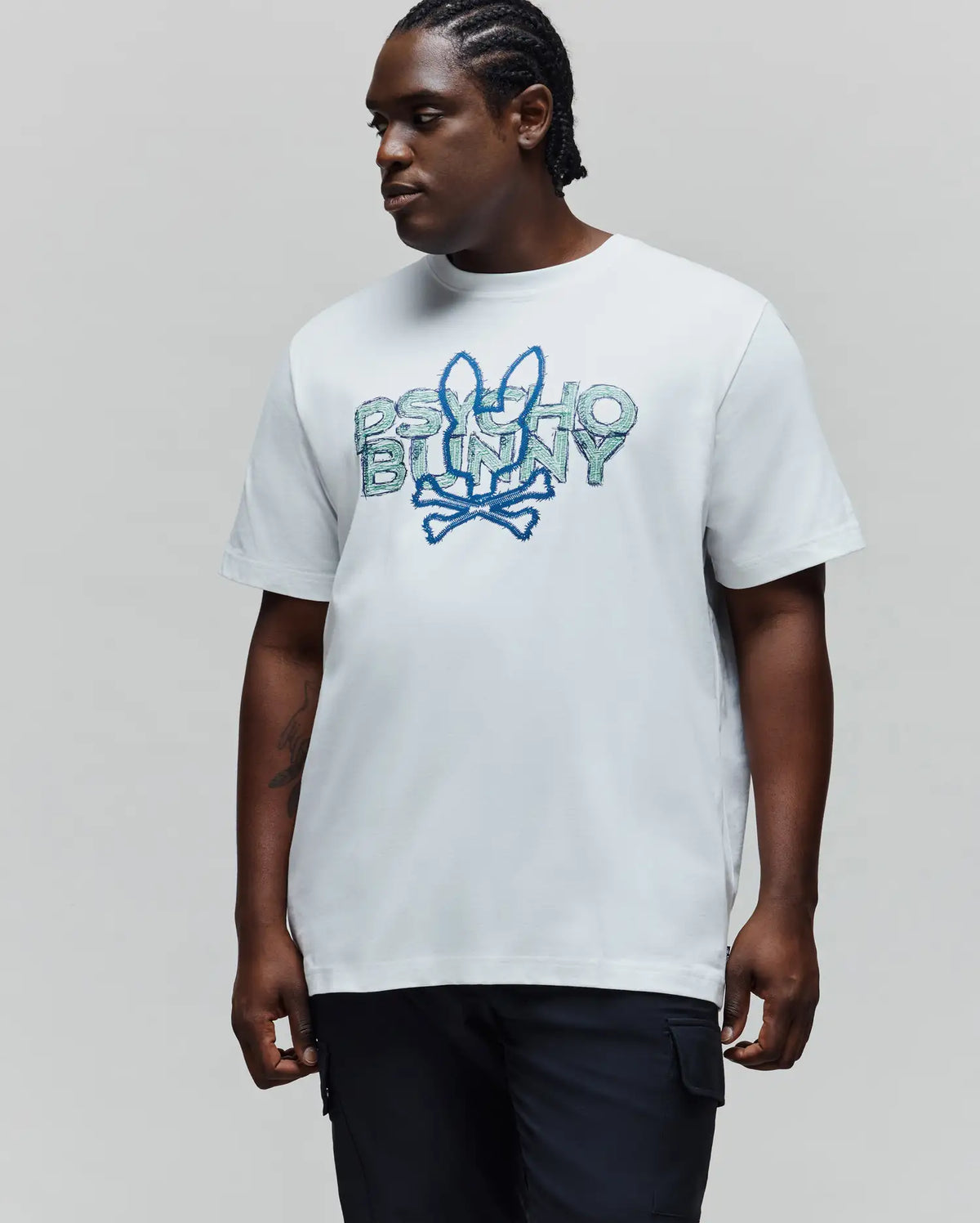 Mens Big And Tall Herman Graphic Tee, a classic fit white jersey t-shirt featuring a large, embroidered Psycho Bunny text and bunny skull logo in shades of blue and green on the chest.