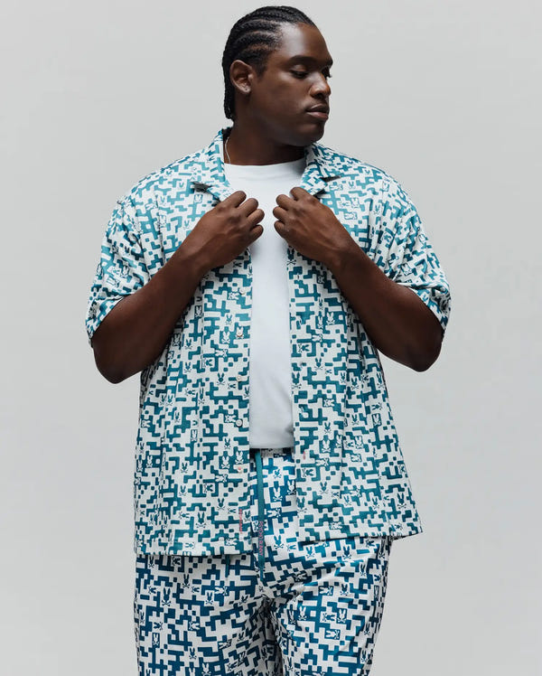 MENS BIG AND TALL JOSH JACQUARD SHIRT featuring a relaxed fit, short sleeves, and an all-over white and teal pixelated geometric pattern with integrated Psycho Bunny skull logos.
