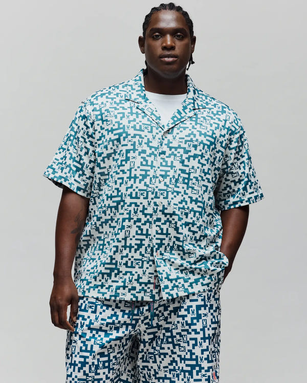 Mens Big And Tall Josh Jacquard Shirt, a relaxed fit short-sleeve camp collar shirt in white with an all-over teal pixelated pattern featuring small Psycho Bunny skull logos.