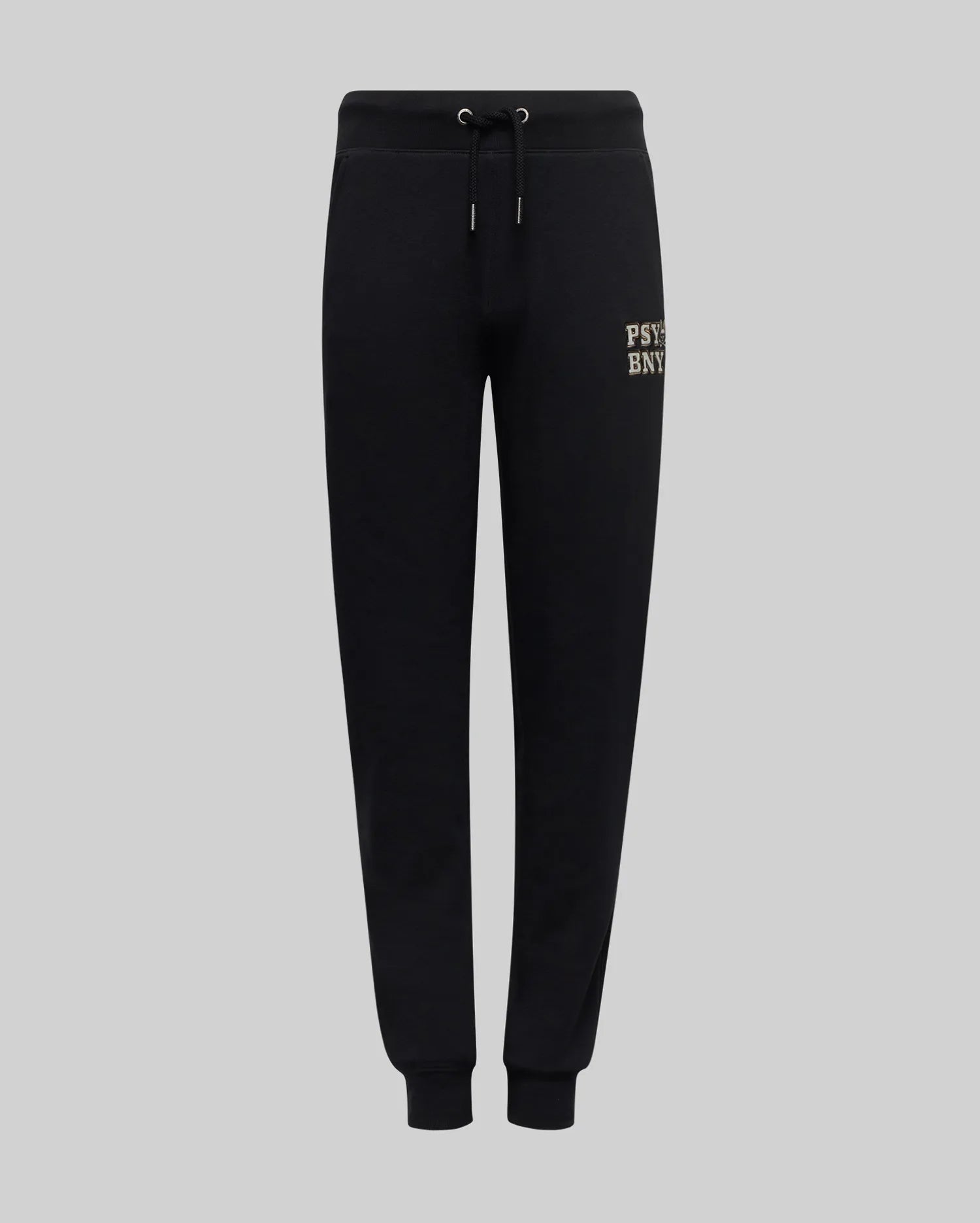 The Psycho Bunny KIDS WADE SWEATPANT (KB0800002) features black jogger pants with an elastic waistband, drawstrings, cuffed ankles, and a small beige embroidered wordmark on the upper left thigh, made from a premium cotton blend.