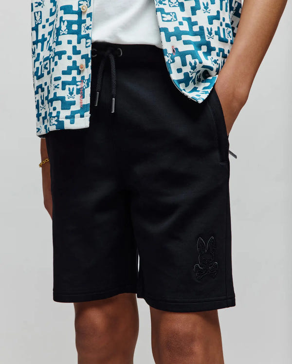 Kids Barry Modal Short in black, featuring a relaxed fit, smooth modal fabric, drawstring waist with silver tips, and a tonal embroidered Psycho Bunny skull logo on the lower left leg.