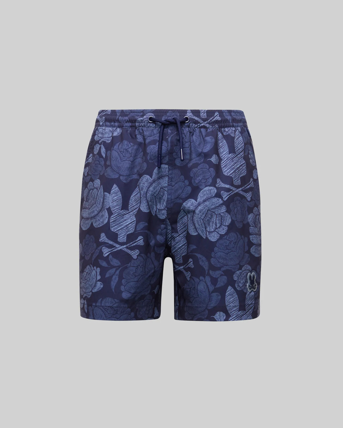 Psycho Bunny KIDS ROWEN SWIM TRUNK (KB1000009) in navy with light blue floral and leaf print, quick-dry fabric, drawstring waist, and small embroidered logo on the left leg, shown on a plain gray background.