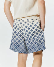 Kids Tobias Swim Trunk, cream with a bold, all-over navy blue geometric pattern featuring the iconic Psycho Bunny skull logo, offering a relaxed fit in smooth, quick-dry fabric. (2)