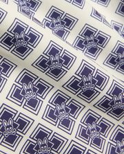 Kids Tobias Swim Trunk in cream with an all-over navy blue geometric square pattern featuring repeated Psycho Bunny skull logos on smooth woven fabric. (6)