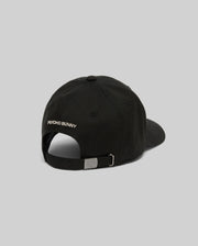 The KIDS WADE BASEBALL CAP - KO1500016 by Psycho Bunny is a black cotton twill cap shown from the back with "PSYCHO BUNNY" text, a white embroidered Bunny on the left, and an adjustable metal buckle strap against a plain light gray background.