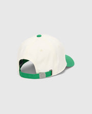 Kids Craig Baseball Cap in cream cotton twill with a vibrant green brim, top button, and adjustable strap featuring an embossed Psycho Bunny skull logo on the silver-tone metal buckle. (4)