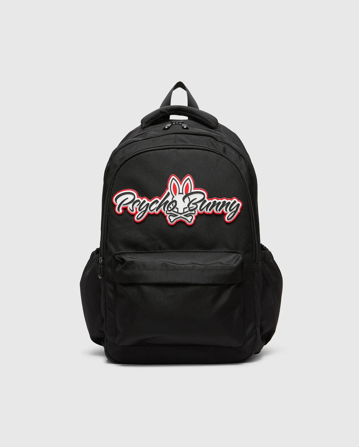 Black KIDS PAL BACKPACK with a large, centered white and red Psycho Bunny skull logo, featuring a front zip pocket and side pockets, made from durable woven fabric. (5)