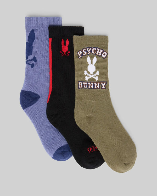 The Psycho Bunny KIDS 3 PACK SPORT SOCK (KO2200005) includes blue, black, and olive crew styles, each with a bunny-and-crossbones. The olive pair is finished with bold white “Psycho Bunny” lettering.