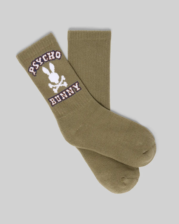 The KIDS 3 PACK SPORT SOCK - KO2200005 by Psycho Bunny includes olive green cotton socks with a white skull and crossbones with bunny ears, plus "Psycho Bunny" in white and purple on the side, shown flat on a light gray background.