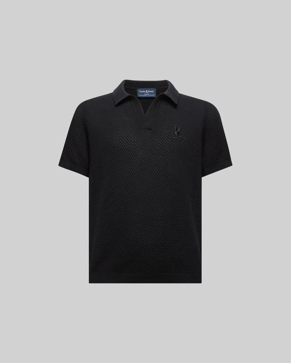 Kids Devon Knit Polo, black textured knit with a V-neck collar, classic fit, and a small tonal embroidered Psycho Bunny skull logo on the left chest.
