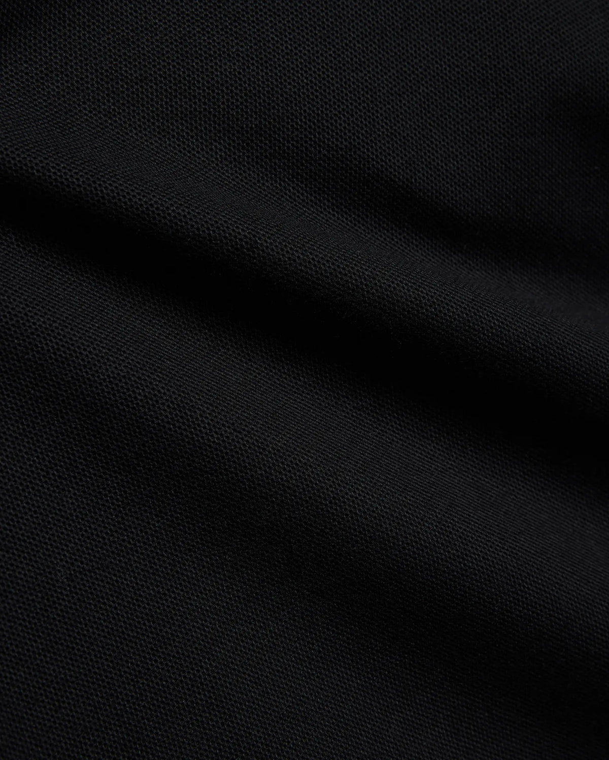 Psycho Bunny Kids Stan Pique Polo in deep black, showcasing the premium, breathable pique knit fabric with a subtle texture, perfect for refined streetwear. (6)