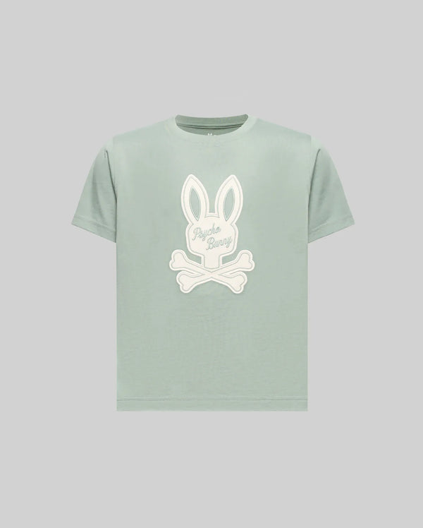 The Psycho Bunny KIDS DEREK CENTER GRAPHIC TEE (KT0200006) is a light green regular-fit short-sleeve T-shirt made from soft Pima cotton, featuring a large white bunny head with crossbones and "Psycho Bunny" text on the front.