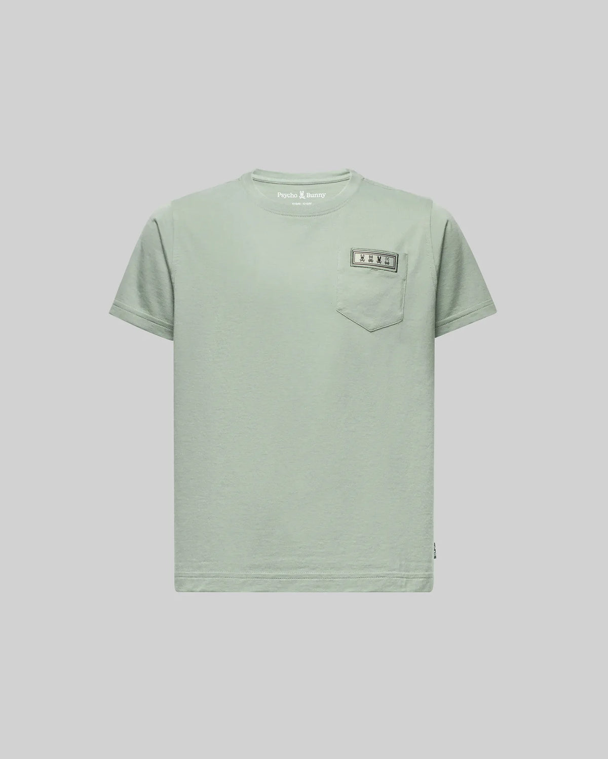 The KIDS AXTON POCKET TEE (KT0200034) by Psycho Bunny is a light green, short-sleeve Pima cotton tee with a left chest pocket and a small sewn rectangular label above it, shown on a plain light gray background.