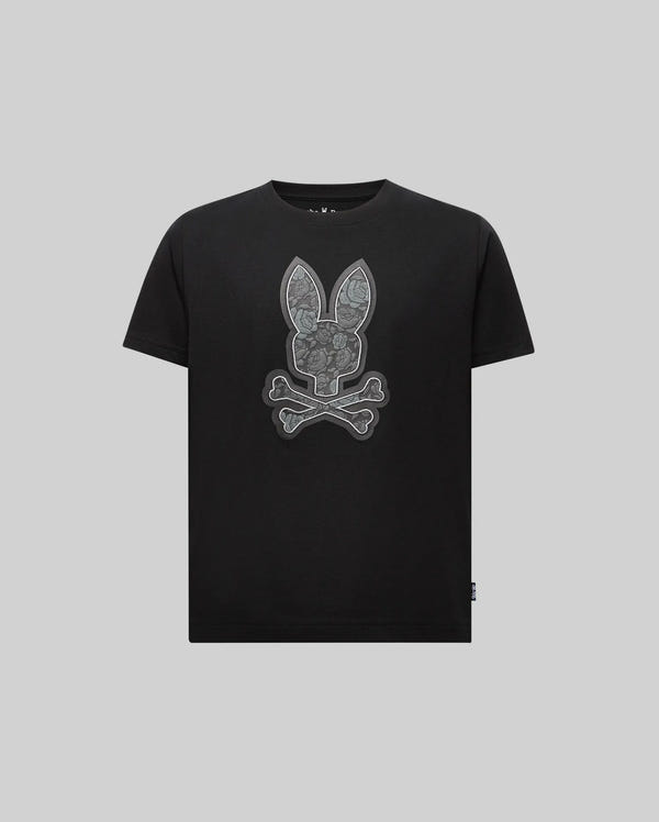 The Psycho Bunny KIDS ROWEN BUNNY GRAPHIC TEE (KT0200058) features a large bunny head above crossed bones on the front. Made from soft Pima cotton in Peru, this black short-sleeve tee has a plain light gray background.